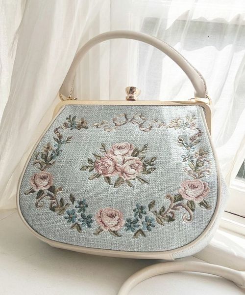 アンアナザーアンジェラス　リボンローズ刺繍がま口バッグ　ブルー an another angelus（アンアナザーアンジェラス）の「リボンローズ刺繍